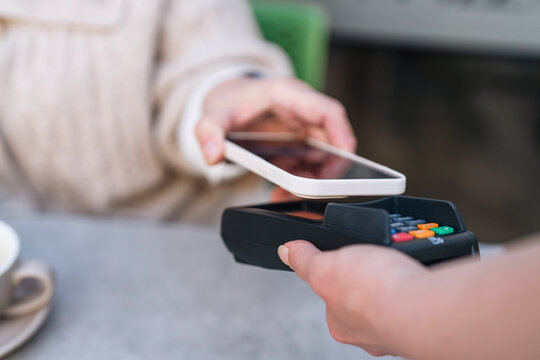 Payment transaction occurring at a cafe with contactless technology in use during afternoon hours