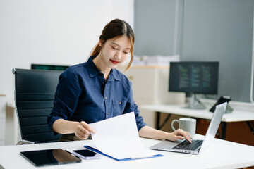 Confident businesswoman working on laptop in a modern office. Elegant and focused, perfect for themes of remote work