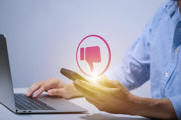 Man using smartphone or tablet, pointing finger at dislike button, thumbs down button, Interface,Thumbs up icon, display screen, touch screen, Virtual Image Technology