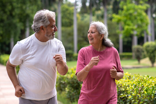 Indian happy senior couple jogging in the park.