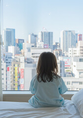 Fototapeta premium 病室のベッドに座る子どもの後ろ姿・写真素材・窓