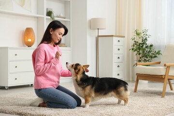 Woman training her dog on floor at home