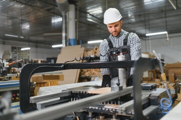Carpenter working with cnc machine in furniture factory