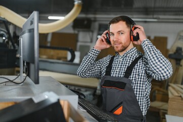 Skilled worker operating cnc machine in furniture factory