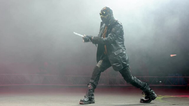 A circus show with knife throwing in the circus arena. The man in the mask dreams of knives.