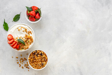 Healthy breakfast flat lay. Yogurt with muesli and strawberry in bowl. Top view