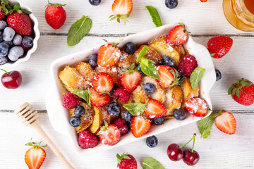 Summer fruit and berry french Toast baked Casserole. Homemade hot tasty delicious french Toast baking, breakfast cake with cream, toast bread and fresh strawberry, blueberry, raspberry and cherry
