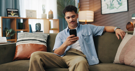 Obraz premium Relax, smile and man with mobile in home for communication, chat and reading message. Sofa, online and happy person with smartphone for texting, social media and browsing website to download app