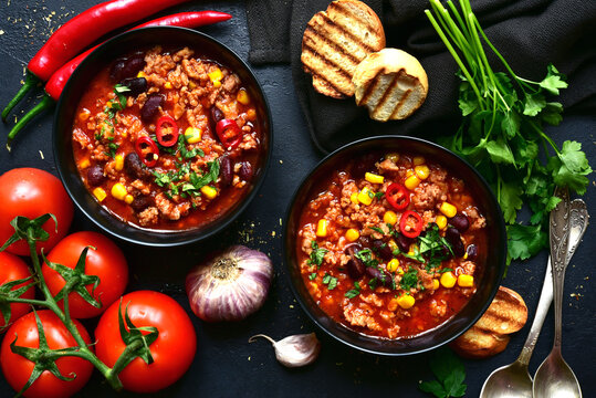 Chili con carne - traditional mexican minced meat and vegetables stew in tomato sauce. Top view with copy space.