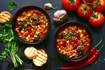 Chili con carne - traditional mexican minced meat and vegetables stew in tomato sauce. Top view with copy space.