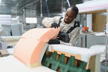 African american Furniture maker assembling sofa in upholstery workshop