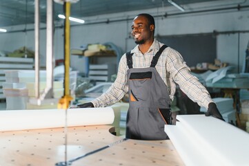 Furniture maker cutting foam for sofa manufacturing in upholstery workshop
