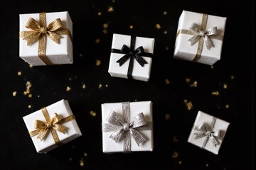 bunch of presents with gold ribbons and confetti on a black background