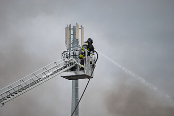 Smoke surrounds the firefighter as he tries to put out the flames