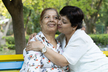 Obraz premium Close up shot of senior mother and daughter embracing at park