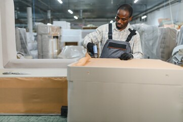 African american Carpenter upholstering furniture in a furniture factory