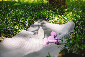 The items include a yoga mat, two dumbbells, a white water bottle