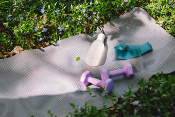 The items include a yoga mat, two dumbbells, a white water bottle