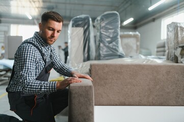 Furniture maker assembling sofa in upholstery workshop