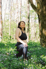 Pregnant woman doing fitness outdoors.