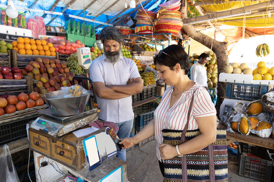 Indian woman purchasing vegetables on grocery market