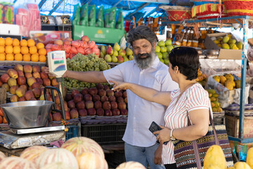 Indian woman purchasing vegetables on grocery market