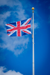 Omaha Beach, France - 05 15 2025: View British flag of the Allies of the Second World War in a blue sky background..