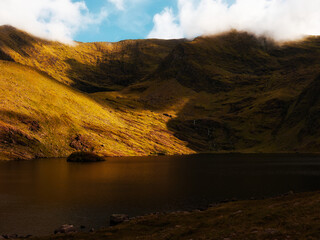 Lough Callee presents a striking landscape with still waters reflecting hills. The surrounding...