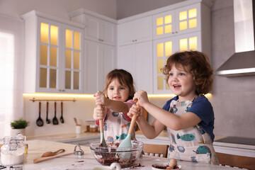 Cooking recipe. Cute children mixing dough for cookies at table in kitchen. Space for text