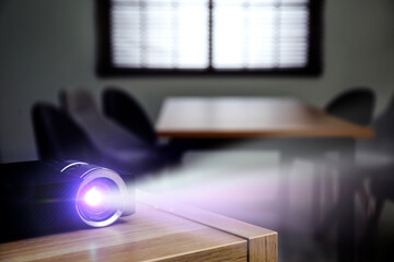 Modern video projector working on wooden table indoors