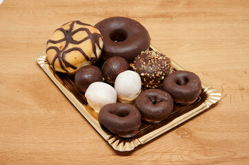 A tray of assorted donuts and other pastries. There are chocolate and white donuts, as well as other pastries