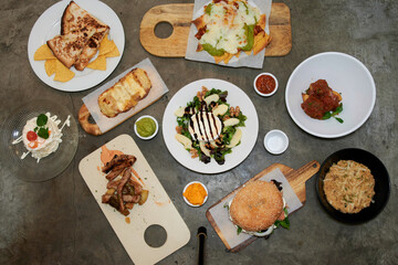 A table with many different types of food, including sandwiches, salads, and desserts. There are also several bowls and plates on the table
