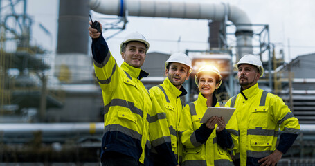 Male and female industrial engineers wearing hard hats talk to collaborate on new project. Team of...