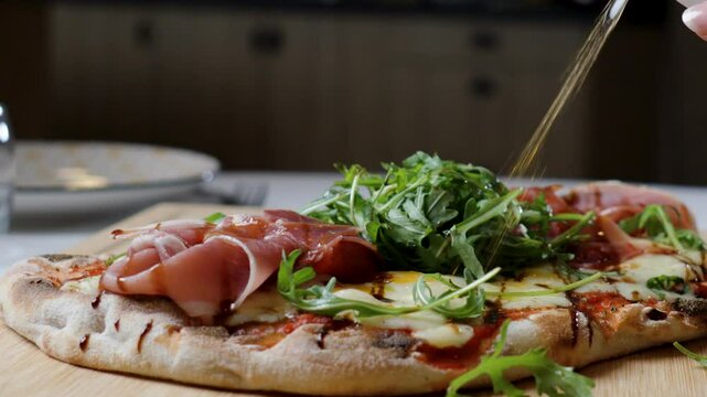 slowmotion of a chef adding salad dressings ontop of a freshly baked pizza