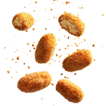 Floating croquettes bursting with filling golden isolated on transparent background