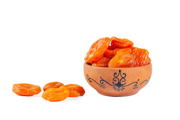 Dried apricots in a clay bowl isolated on white background.