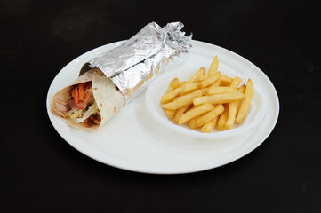 A plate of food with a burrito and french fries. The plate is white and the food is silver