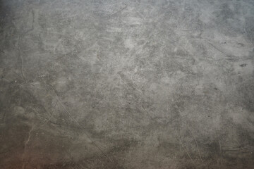 A grey wall with a few scratches on it. The wall is made of concrete. There are no people or objects visible in the image