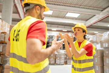 Two warehouse workers in a dispute, showcasing emotions and communication in a hectic warehouse...