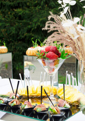 Italian style appetizer,antipasto skewer or caprese on stick with cheese,olives,prosciutto and pear.Beatifully decorated banquet catering table.Corporate birthday party event or wedding celebration.