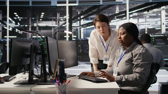 Data center team leader and IT expert reviewing performance dashboards of AI equipment rigs. Server room manager oversee system administrator examining machine learning algorithms on screen, camera A