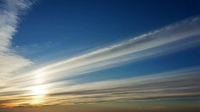 Dramatic sky with altocumulus clouds and warm light at the horizon creating a scenic skyscape with bands of clouds.