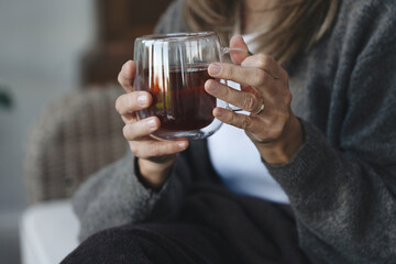 Warm beverage in hand, a person enjoys a moment of tranquility in a cozy indoor space during the afternoon