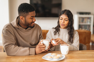 Coffee break with pastries shared between a couple at home in a cozy kitchen setting during the afternoon
