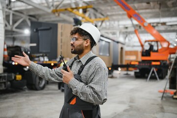 Arab engineer coordinating modular house production in construction workshop