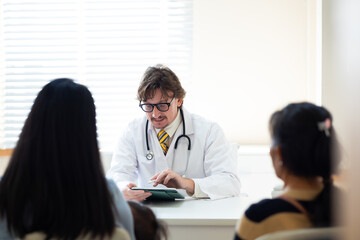 Fototapeta premium advice, consult : Hospital Healthcare medical and medicine. Caucasian male doctor giving advice, consult to asian female patient, Preventive Medicine Health Check-up in Progress