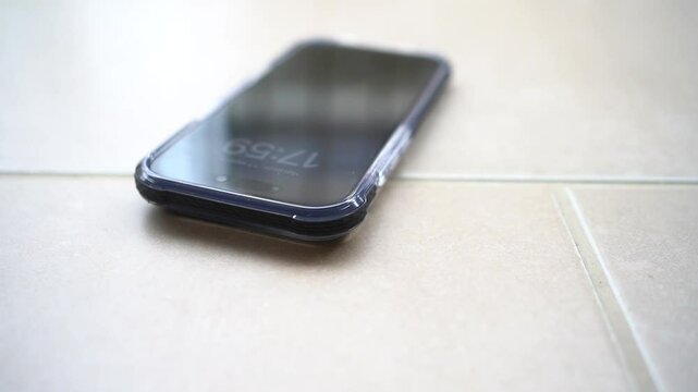 Smartphone in shockproof silicone case on tiled floor after falling.