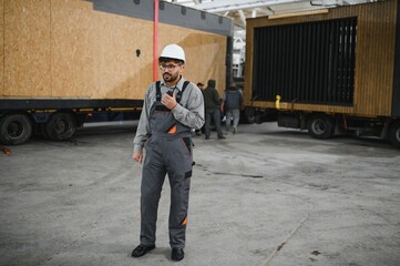 Arab engineer supervising modular house production in construction workshop