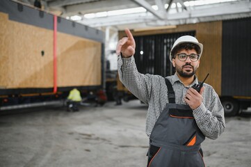 Arab engineer supervising prefabricated modular house production in construction workshop