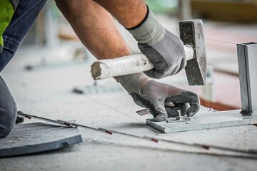 Bauarbeiter befestigt ein Gerüst mit einem Hammer